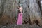 A beautiful girl is standing inside the trunk of an old baobab tree on the island of Zanzibar, Tanzania, Africa