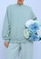 Beautiful Girl Standing In white Room with Flowers In Her Hands. Fresh aqua menthe colours trends. Spring summer collection