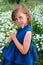 Beautiful girl stands in the field with daisies in summer