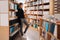 Beautiful girl is studying reading a book while standing on the floor among books in the bookshop