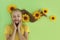 A beautiful girl with sunflowers in her blonde hair and a yellow baby manicure