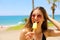 Beautiful girl with sunglasses eating popsicle on Malaga beach in her travel holidays in Southern Spain.