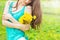 Beautiful girl in a Sunny summer day walking in the garden and keeps yellow dandelions in the hands