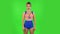 Beautiful girl in a swimsuit is standing, spreads out in a smile. Green screen