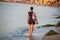 A beautiful girl, a tourist, walks alone on the beach.