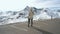 Beautiful girl traveler walks along Majestic Grossglockner Mountain Road in Austria, snow covered sharp peaks of the