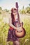 Beautiful girl travelling with her guitar in summer