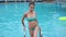 Beautiful girl in turquoise swimsuit resting by poolside, slim woman in bikini climbing out of swimming-pool on ladder