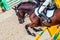 Beautiful girl in uniform and bay dressage horse at showjumping competition.