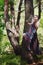 A beautiful girl with a violin in a long dress hovers among the trees.