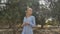 Beautiful girl walking along the plantation with olive trees