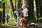 Beautiful girl walking with big dog. Best friend and companion. Cheerful young girl petting dog while standing in forest