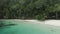 Beautiful Girl Walking On Ocean Beach With Huts Among Palm Trees In Triton Bay, Raja Ampat. Stunning View From Drone