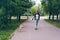 Beautiful girl walking well-bred puppy in green park smiling enjoying summer day