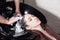 Beautiful girl washes her hair before a haircut in a beauty salon. hair washing at a hairdressing, young caucasian girl