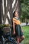 Beautiful girl wearing a nice dress with college look having fun in park with bicycle carrying a beautiful basket. Vintage scenery