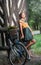 Beautiful girl wearing a nice dress with college look having fun in park with bicycle carrying a beautiful basket. Vintage scenery