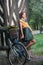 Beautiful girl wearing a nice dress with college look having fun in park with bicycle carrying a beautiful basket. Vintage scenery