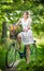 Beautiful girl wearing a nice white dress having fun in park with bicycle. Healthy outdoor lifestyle concept. Vintage scenery