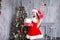 Beautiful girl wearing santa claus clothes . Smiling woman with big and small gift. Women on dress and santa`s hat.