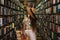 Beautiful girl wearing stylish outfit looking for interesting book in the vintage bookstore