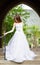 Beautiful girl wearing white wedding dress posing alone on the chapel stairs