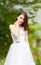 Beautiful girl wearing white wedding dress posing alone on the chapel stairs