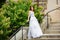Beautiful girl wearing white wedding dress posing alone on the chapel stairs