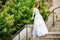 Beautiful girl wearing white wedding dress posing alone on the chapel stairs