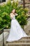 Beautiful girl wearing white wedding dress posing alone on the chapel stairs