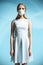 Beautiful girl in a white dress with a respiratory mask on her face