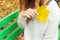 Beautiful girl in a white jacket and black pants with yellow leaves in the hands of sitting on the bench in autumn Park