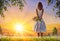 Beautiful girl woman mom with a bouquet of flowers in a summer field admires colorful sunset dawn. Oil painting.