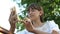 Beautiful girl writes on smartphone a letter in park in spring, summer. A young girl chatting on a tablet with friends