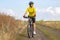 Beautiful girl in yellow riding a bike in nature. Sports and recreation. Hobbies and health