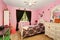 Beautiful girls room in bright pink color with carved wood bed