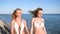 Beautiful girls in swimsuit on paradise islands, sisters holding