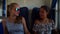 Beautiful girls try on sunglasses and laugh in train