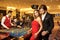 Beautiful glamour couple against the background of casino poker roulette.