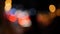 Beautiful glittering bokeh in dark blurry background at night. The round colorful bokeh shine from car lights in traffic