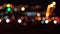 Beautiful glittering bokeh in dark blurry background at night. Round colorful bokeh shine from car lights in traffic jam