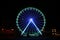 Beautiful glowing Ferris wheel on city street at night