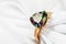 Beautiful gold ring adorned with a large gem, iridescent in different colors on a white silk fabric