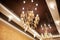 A beautiful golden chandelier on a stretched brown ceiling. Glossy. Mirror reflection, rich lamp for luxurious interior