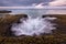 A beautiful golden cloudy evening seascape with misty waves and dramatic rock formations