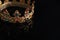 Beautiful golden crown with gems on dark mirror surface, closeup. Space for text