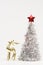 Beautiful golden deer figurine and lush silver Christmas tree with a red star on the top