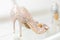 Beautiful golden glitter high heel female shoes on glass shelf. Wedding accessories . Cinderella shoes. Selective focus