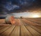 Beautiful golden hour hay bales sunset landscape with wooden planks floor