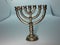 Beautiful golden menorah of Hanukkah on blue background. Menorah with seven lit candles on the table. beautiful